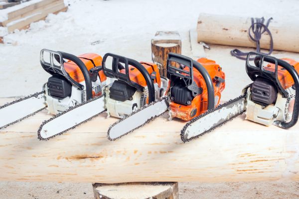 chainsaws sitting on log f16c65a9